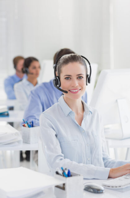 Business team working on computers and wearing headsets in call center